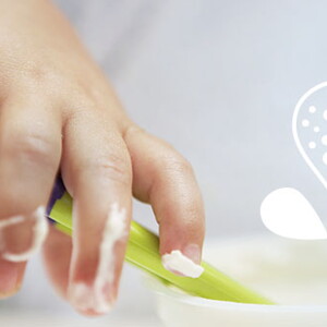 Mano de bebé comiendo puré de verduras